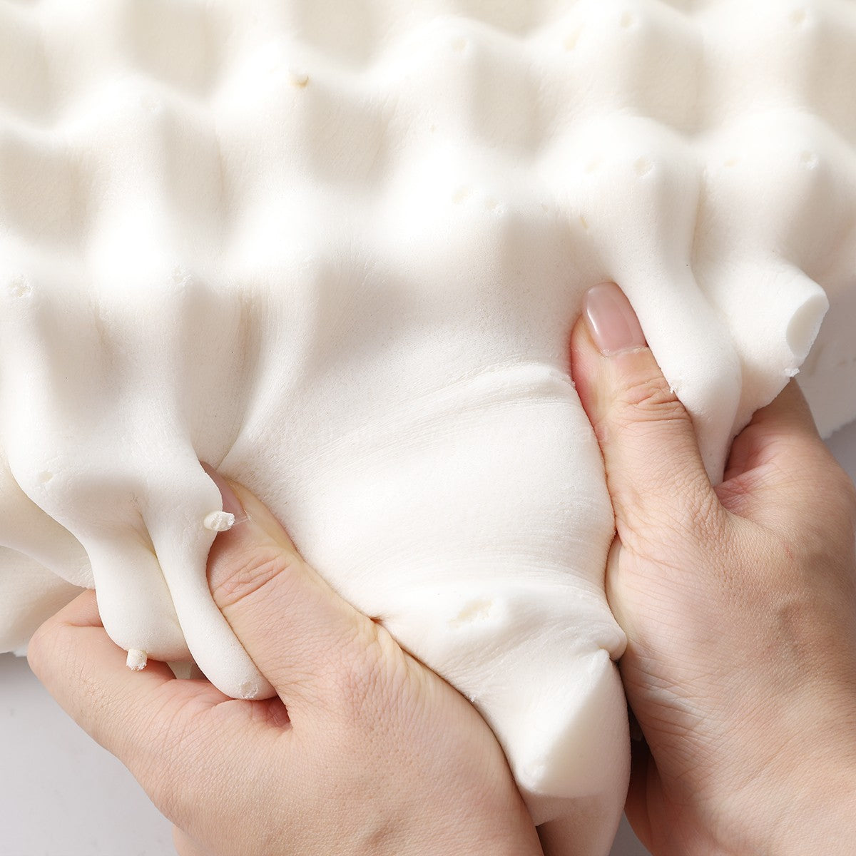 Hand pulling the pillow - PAPATYA Latex Neck Pillow Contour Support with Massage Nodules